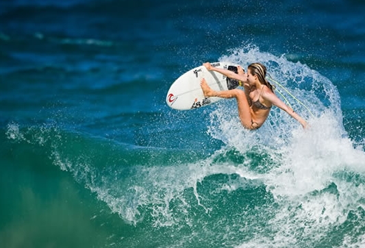 Woman surfing doing a jump